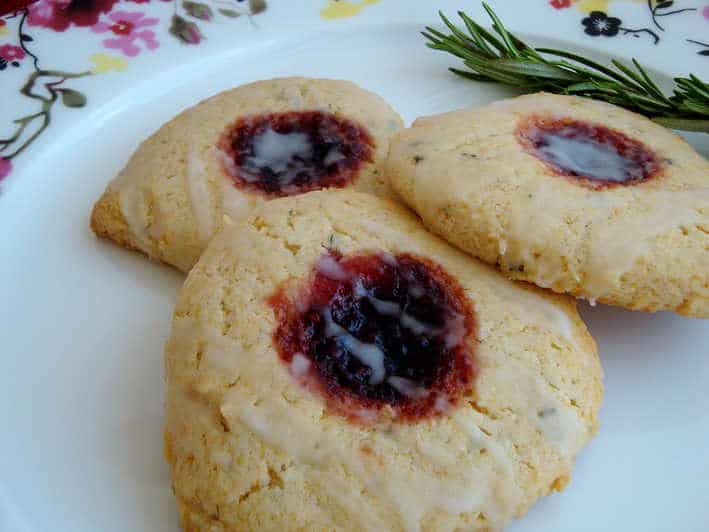 Three Scones with raspberry in the middle served on a white plate