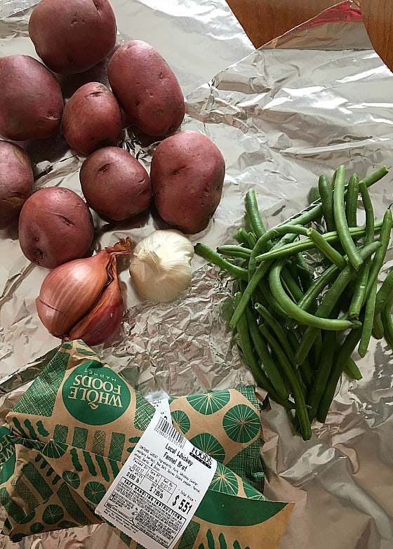  red potatoes, green beans, garlic, shallot, and sausage on foil