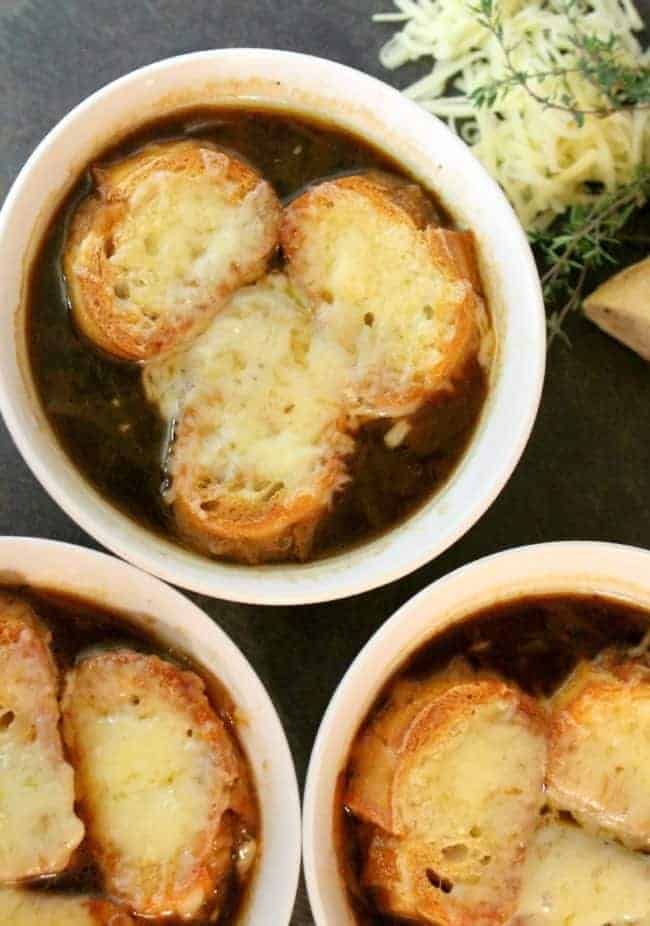 French onion soup in bowls with sliced bread on top