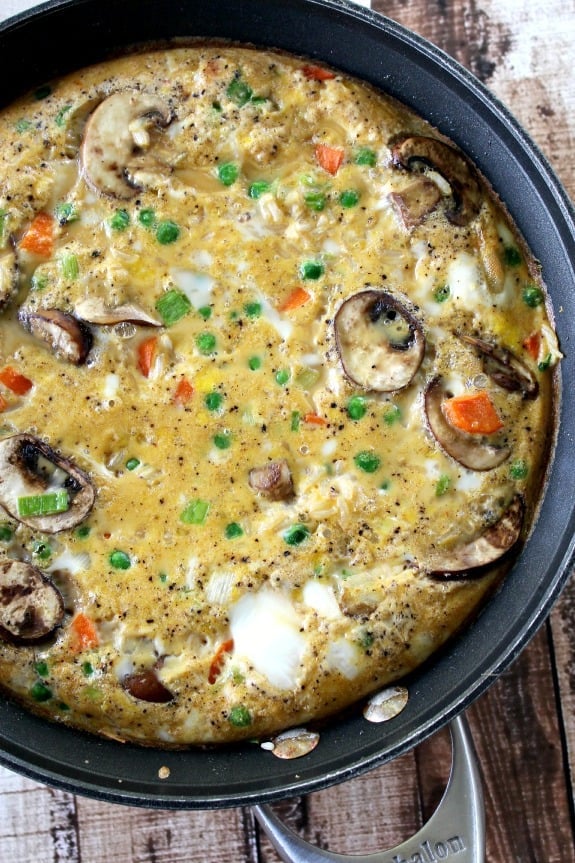 Fried Rice Frittata with mushrooms, peas and carrots in a pan