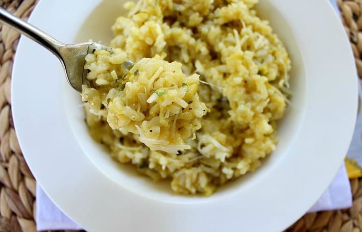 Lemon Zucchini Risotto on a fork served in a white bowl