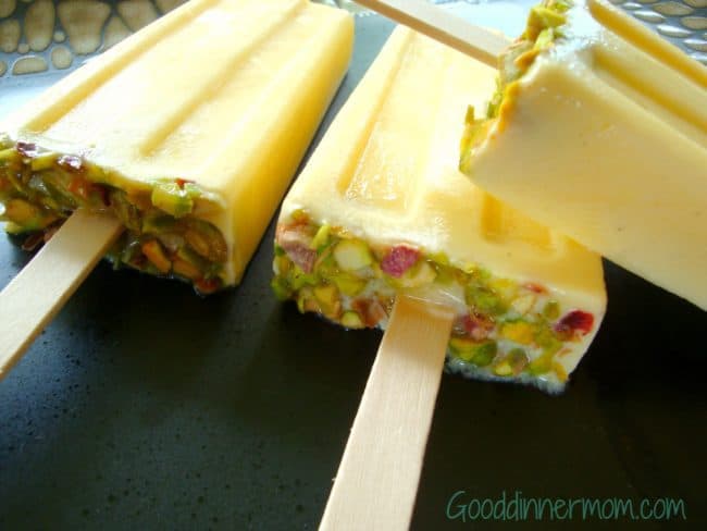 The bottoms of the Mango Lassi Popsicles with pistachio nuts