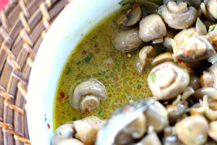 Marinated Mushrooms in marinade served in a white bowl