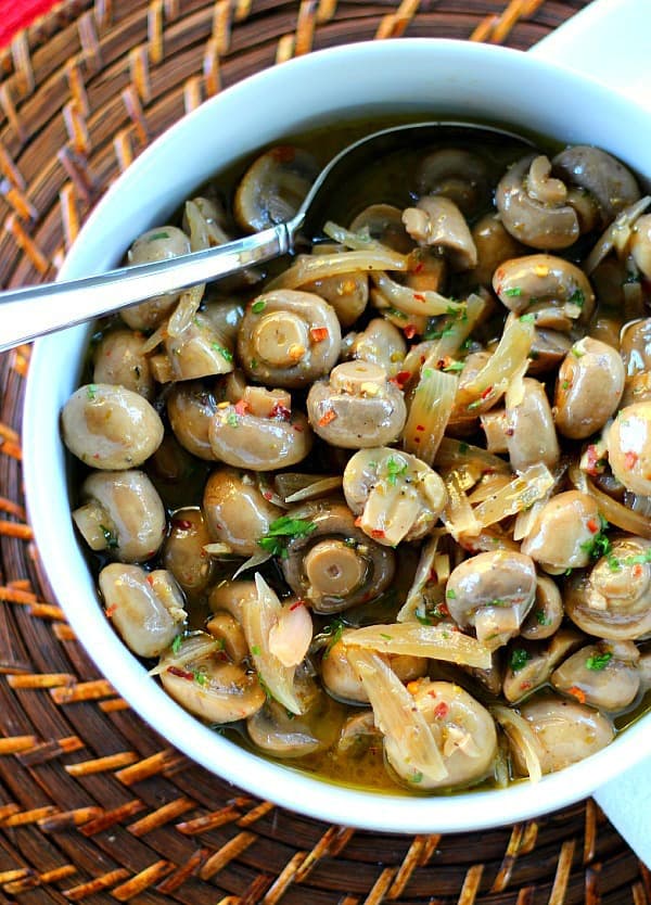 Marinated Mushrooms in a white bowl with a spoon