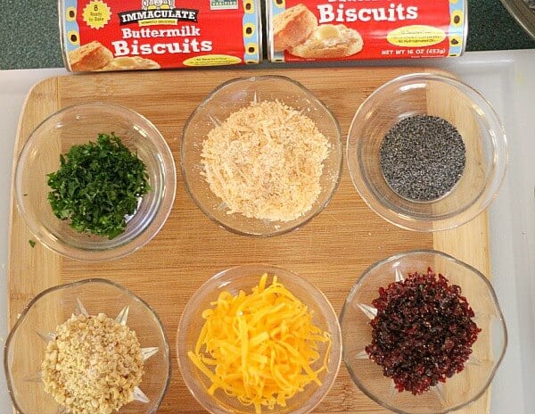  different toppings in small bowls with biscuits on the side
