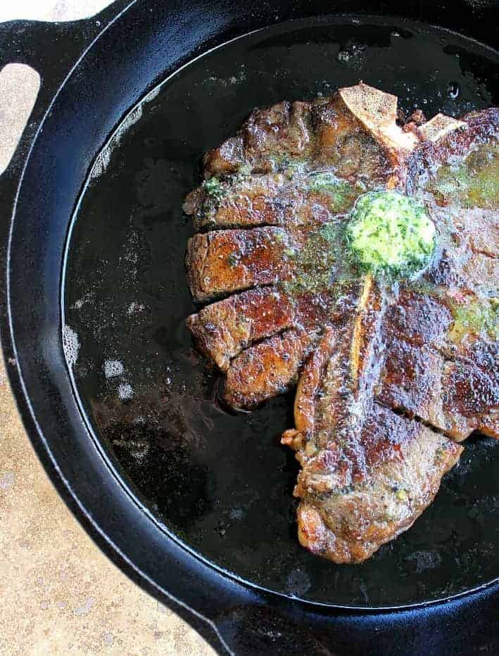 Perfect Porterhouse Steak with Parsley Shallot Butter on top in a skillet