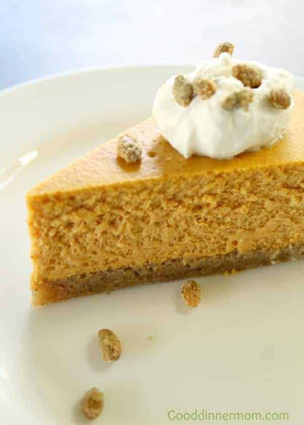 Pumpkin Cheesecake Slice toped wit whipped cream on a white plate