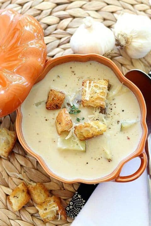 Roasted Garlic Soup with Parmesan Cheese in bowl with croutons on top
