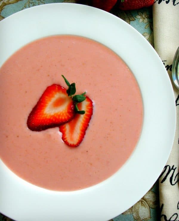 Strawberry Soup served in a white bowl with a sliced strawberry
