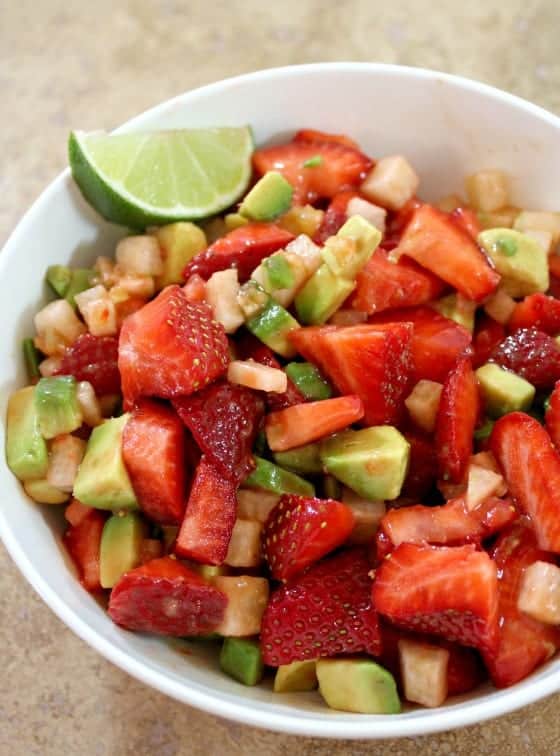 Strawberry Avocado Salad in a white bowl with a lime wedge