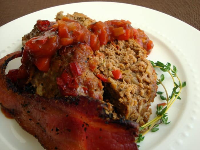 World's Best Meatloaf with tomato relish and bacon on the side, served on a white plate