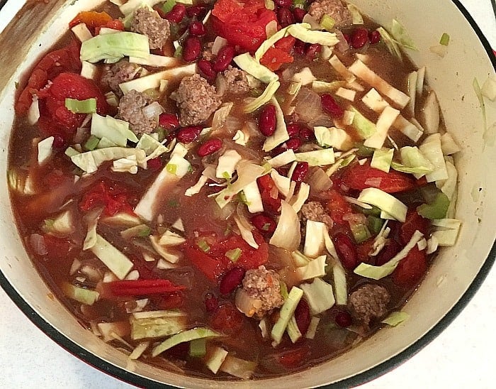 Cabbage, beef, beans, tomato and celery in white pot