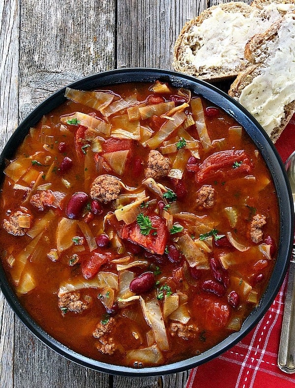Cabbage Soup in black bowl with beans, ground beaf, tomatoes