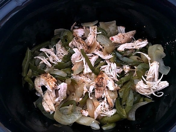 cooked peppers, onions and shredded chicken in slow cooker