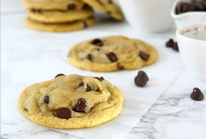 chocolate chip cookies on marble with measuring cups