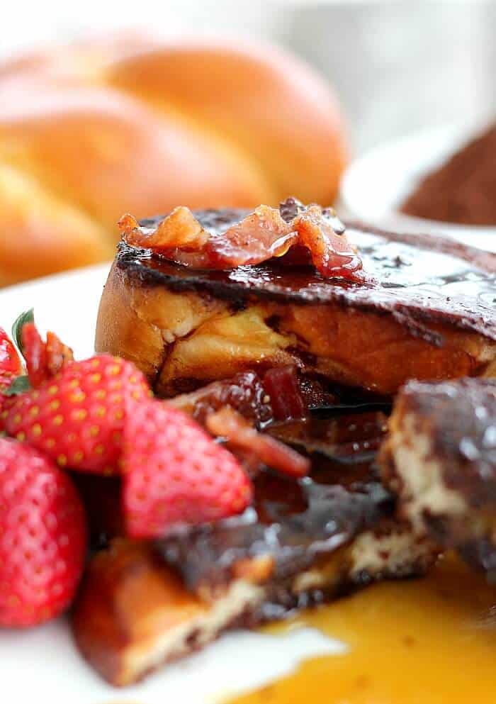 Chocolate French Toast with candied bacon on top and strawberries