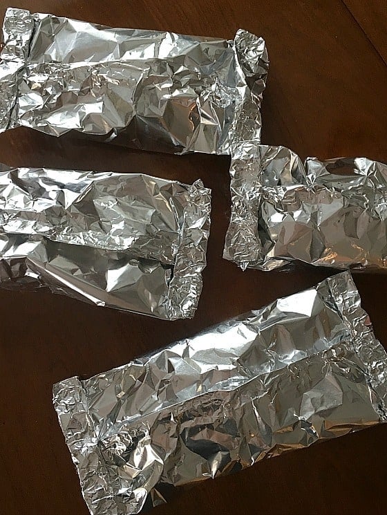 four wrapped foil dinners ready to be baked