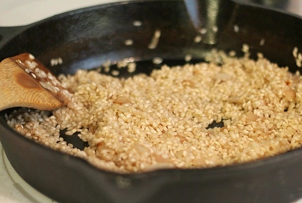  Risotto being added to the onions in a skillet